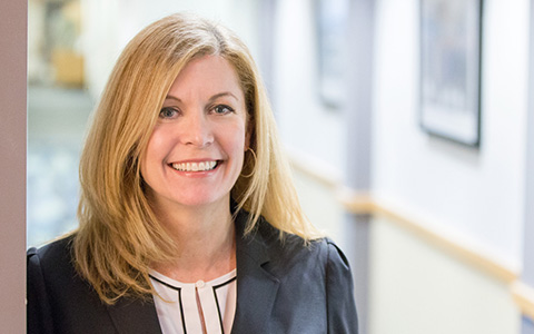 Elizabeth Bennett wearing a dark suit jacket pictured in an office setting.