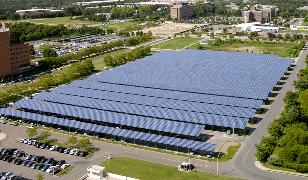 Solar panels are installed over parking spaces to maximize solar energy collection.