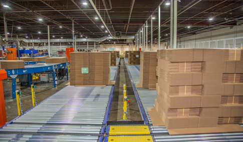 Manufacturing area in Rand-Whitney’s facility with stacks of corrugated packaging. 