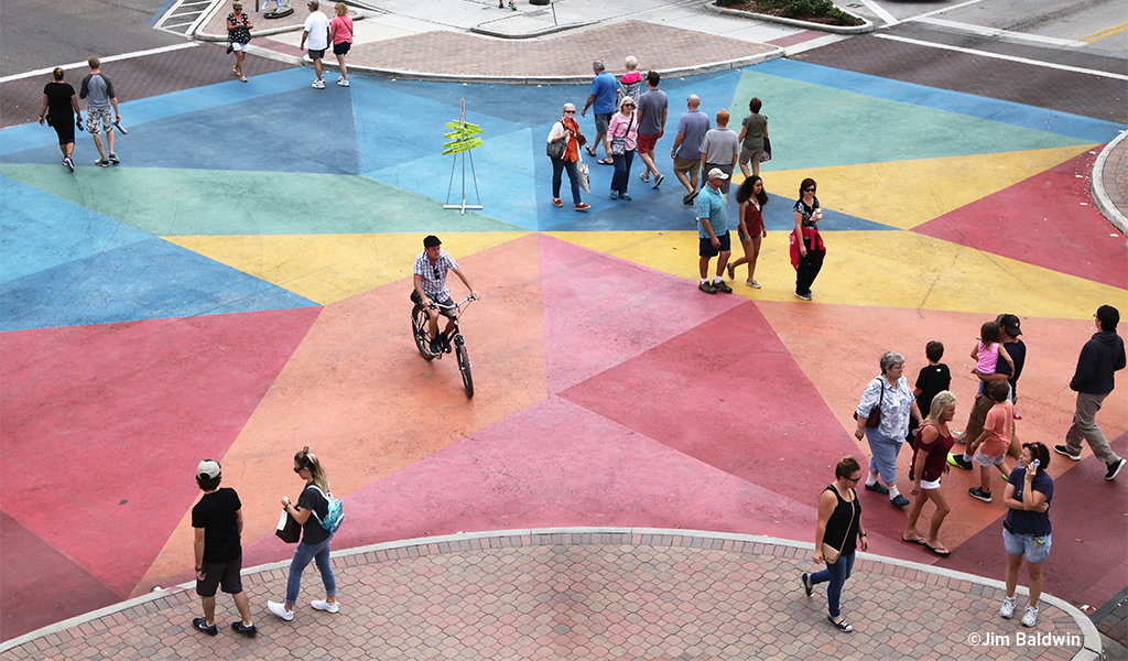 People cross an artistically painted intersection in St. Petersburg.