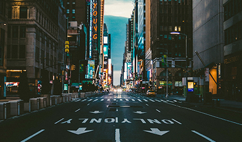 A downtown city street nearly empty of cars.