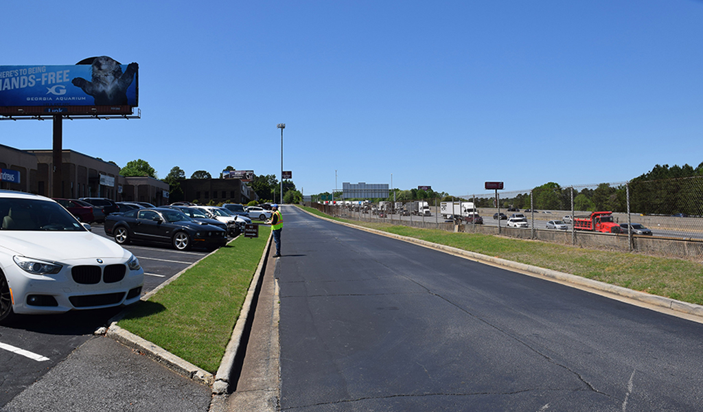 A man stands near a road alongside I-285 in Georgia.