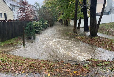 Flooding between fenced in backyards in residential neighborhood.