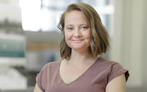 Cassi Patterson standing indoors wearing a brown shirt.