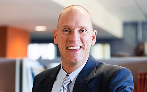 Rob Smedberg smiling, wearing a navy blazer.