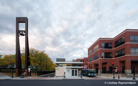 A downtown transit center with bus, sidewalk, and wheelchair access.