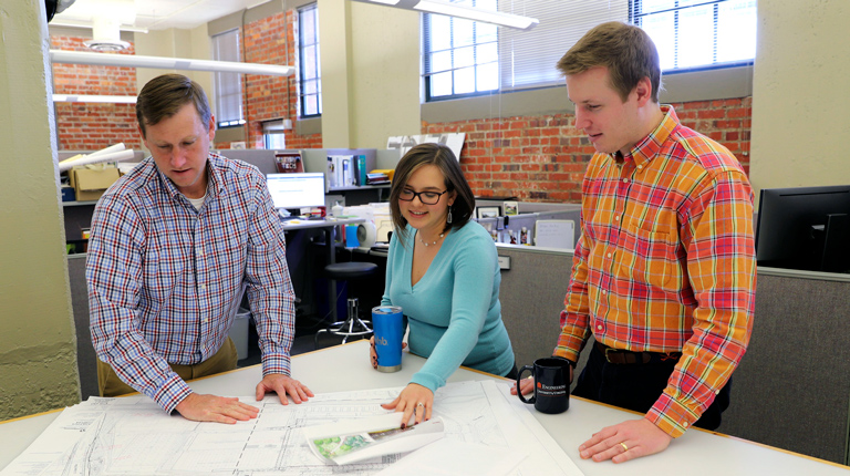 Three VHB employees collaborate on site engineering plans