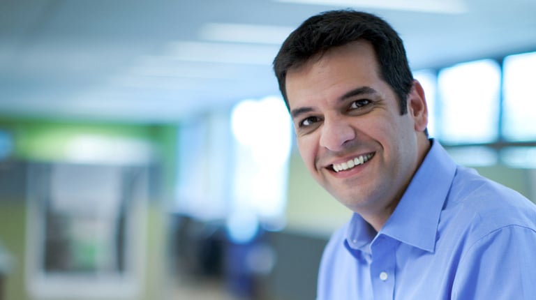 Fabricio with dark hair wearing a blue button down shirt.