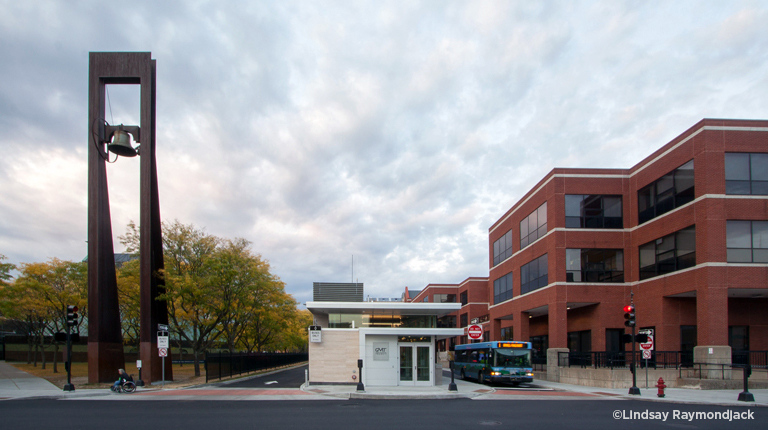 A downtown transit center with bus, sidewalk, and wheelchair access.