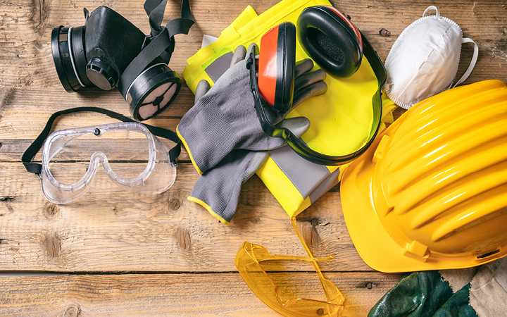 Construction and protective equipment laid out on a wooden table. 