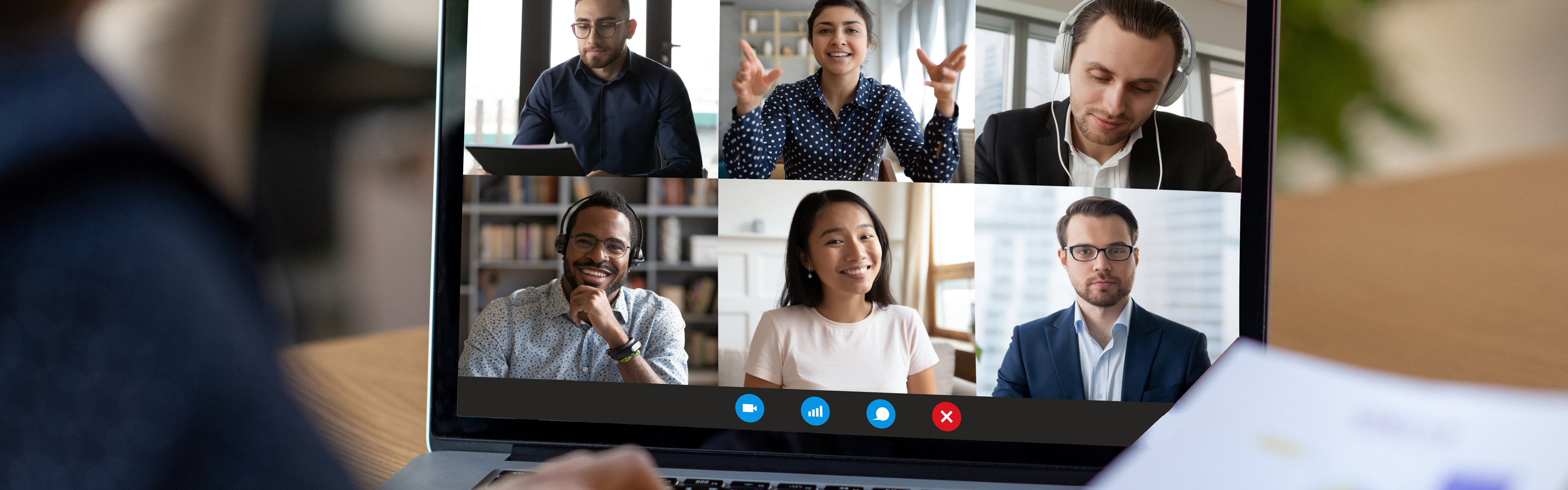 A laptop showing images of people participating in a virutal meeting. 