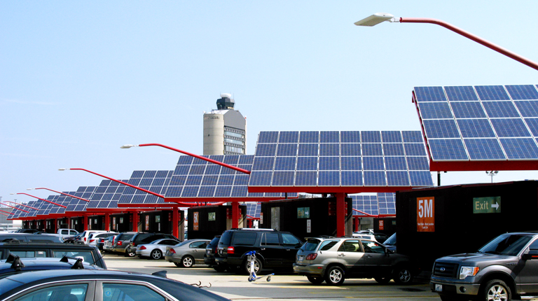 Solar panels are incorporated as part of an airport parking facility.