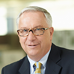 Steve Thomas in a dark gray suit and yellow tie