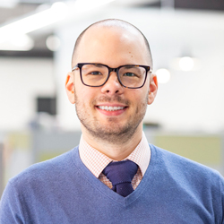 Donny Goris-Kolb wearing a blue sweater and glasses. 