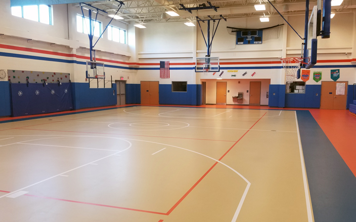 Gymnasium with multi-colored floor and blue, padded walls.