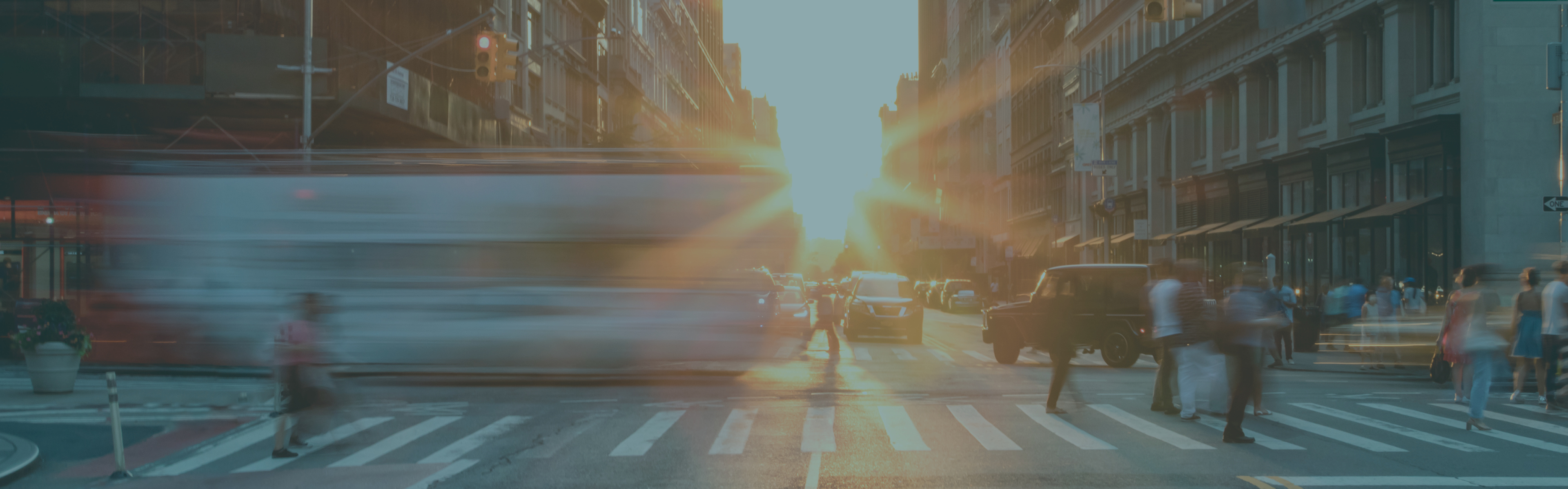 Busy New York City street scene with crowds of people in Midtown Manhattan with sunset background